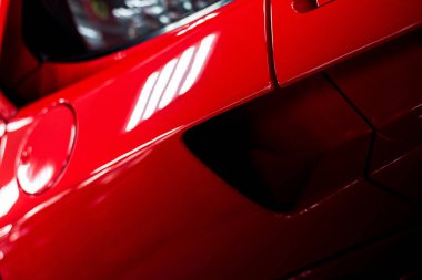 Kırmızı, modern bir yarış arabasının vücut öğeleri. Kapalı ve bulanık arka plan.