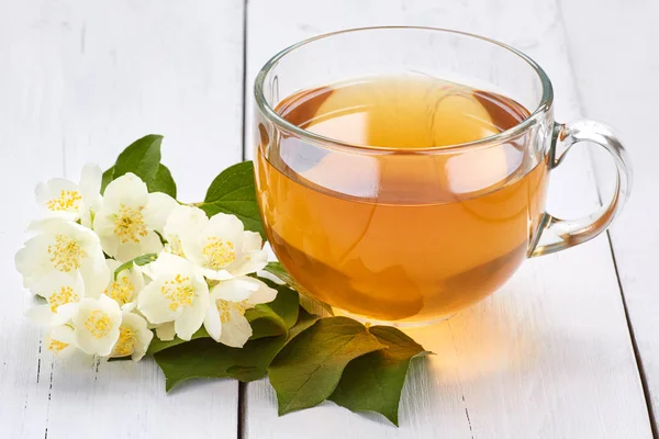 Jasmine tea and jasmine flowers on a white wooden table