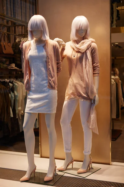 Mannequins standing in store window display of womens casual clo