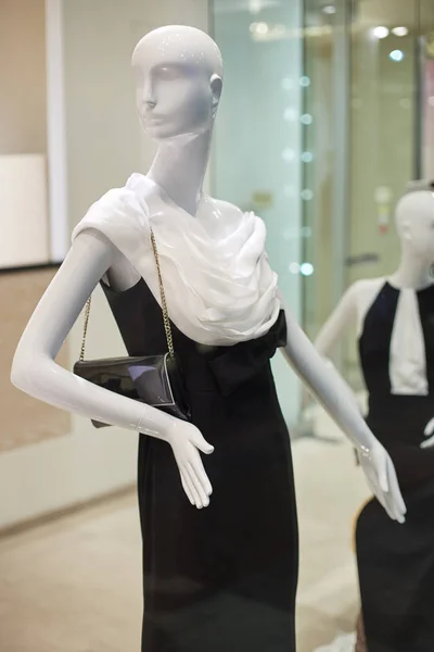 Mannequins standing in store window display of womens casual clo