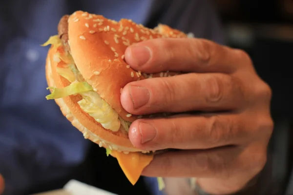 Man holding a hamburger — Stock Photo, Image