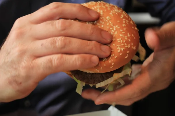 Man holding a hamburger — Stock Photo, Image