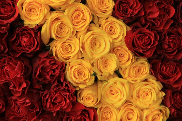 Röda och gula rosor i en bröllop arrangemang — Stockfoto