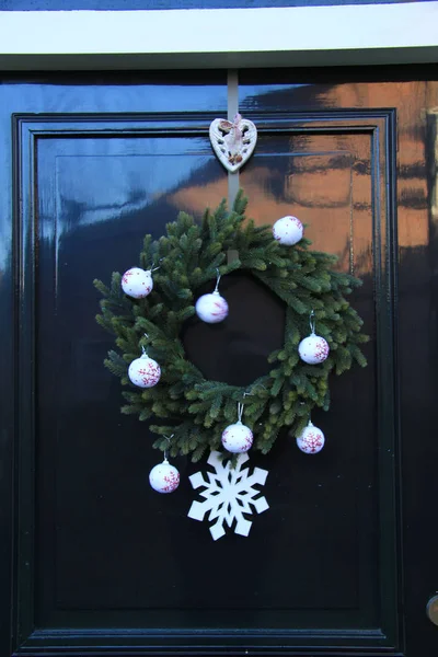 Classic christmas wreath with decorations on a door — Φωτογραφία Αρχείου