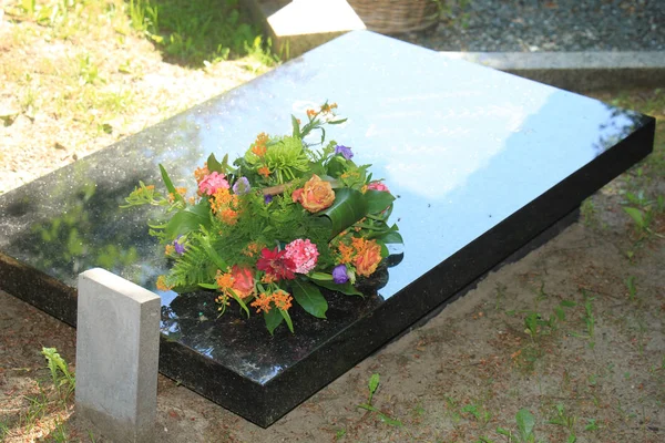 Grave with sympathy flowers — Stock Photo, Image