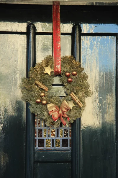 Classica corona di Natale con decorazioni su una porta — Foto Stock
