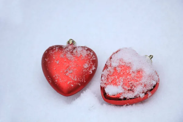 Red heart ornaments in snow — Stock Photo, Image