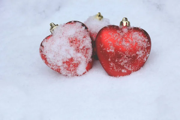 Enfeites de coração vermelho na neve — Fotografia de Stock