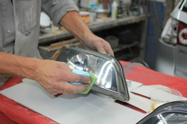 Homem remodelando farol do carro — Fotografia de Stock