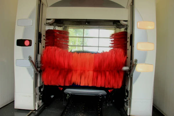 Suv Azul Uma Lavagem Automática Carro Com Grandes Escovas Vermelhas — Fotografia de Stock