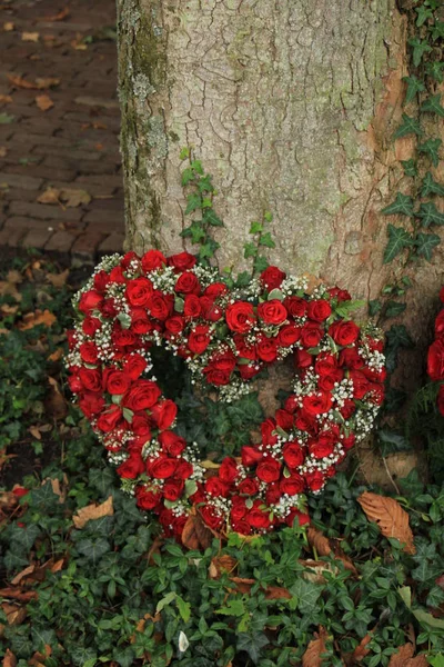 Συλλυπητήρια Λουλούδια Κοντά Ένα Δέντρο Ένα Νεκροταφείο Κόκκινα Τριαντάφυλλα Σχήμα — Φωτογραφία Αρχείου