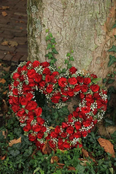 Red Heart shaped sympathy flowers — Stock Photo, Image