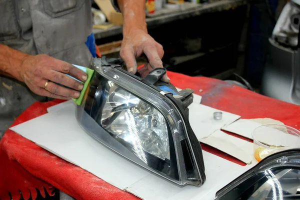 Man refurbishing car headlight — Stock Photo, Image