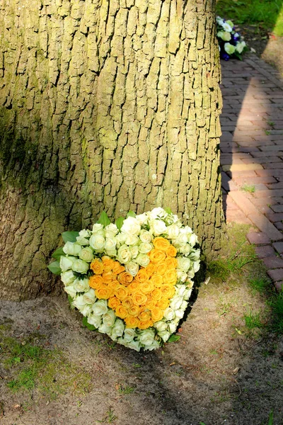 Sympathy flowers near a tree