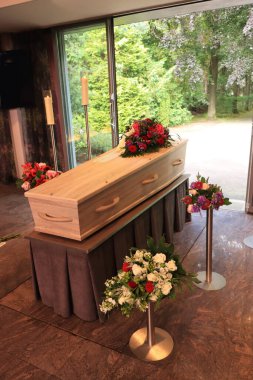 Morgda çiçek aranjmanı olan bir tabut, cenaze servisi.