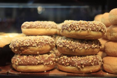 Vitrinde fındıkla süslenmiş buzlu çikolatalı çörekler.