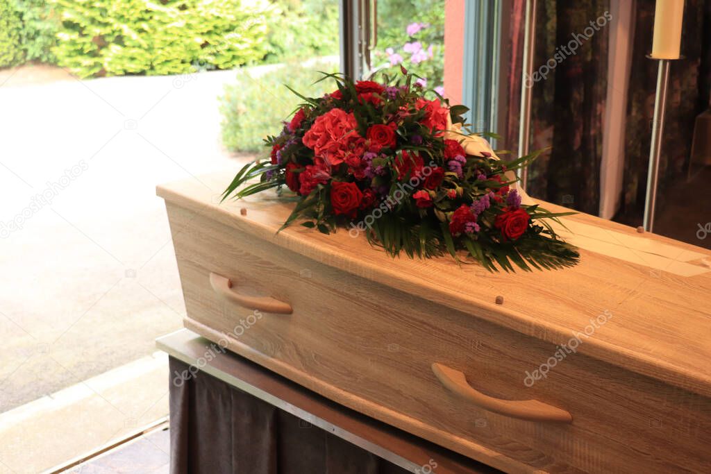 A coffin with a flower arrangement in a morgue, a funeral service