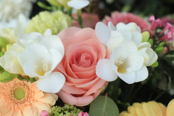 Mixed yellow pink flower arrangement: various flowers in different shades of yellow and pink for a wedding