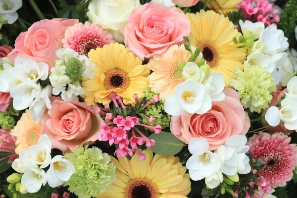 Mixed yellow pink flower arrangement: various flowers in different shades of yellow and pink for a wedding