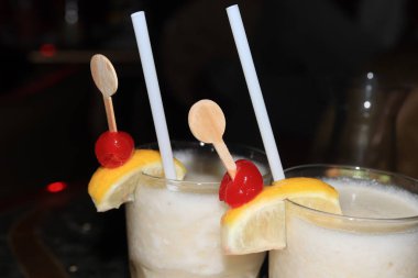 Büyük bardakta pina colada kokteyli, ahşap karıştırıcı ve taze meyve ile süslenmiş. Yolcu gemisi kokteyli.