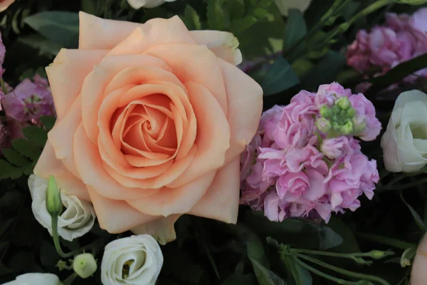 Peach colored roses in a big wedding centerpiece