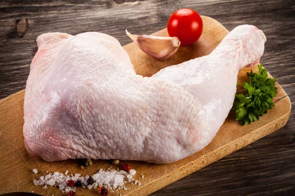 Raw chicken leg on cutting board — Stock Photo, Image