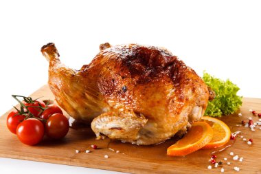 Roast chicken on cutting board on white background clipart