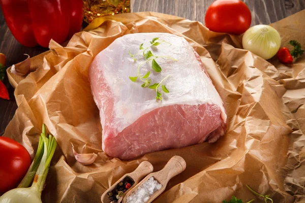 Fresh raw pork with vegetables on wooden bacground — Stock Photo, Image