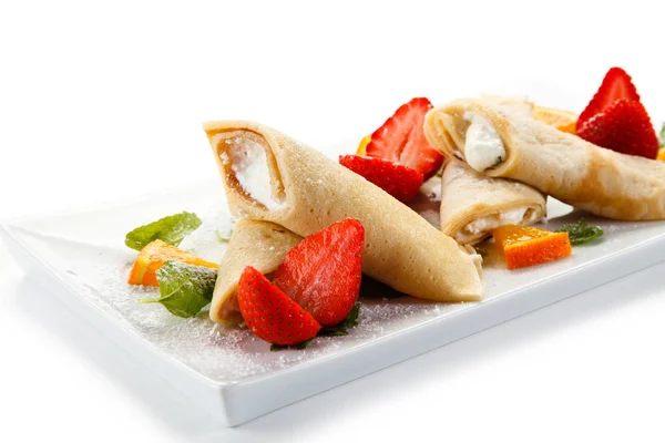 Crepes with strawberries, oranges and cream on white background — Stock Photo, Image