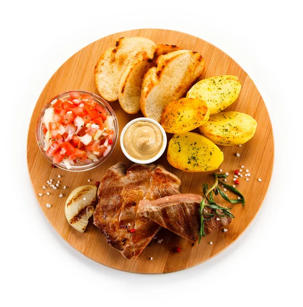 Steaks with potatoes, toasts and vegetables — Stock Photo, Image