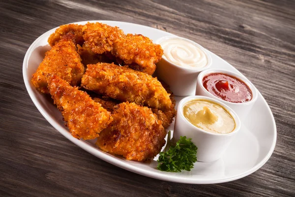 Nuggets de frango frito no fundo de madeira — Fotografia de Stock