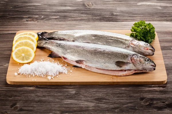 Fresh raw trouts on cutting board — Stock Image Fresh Raw Trouts Cutting Board Stock Photo