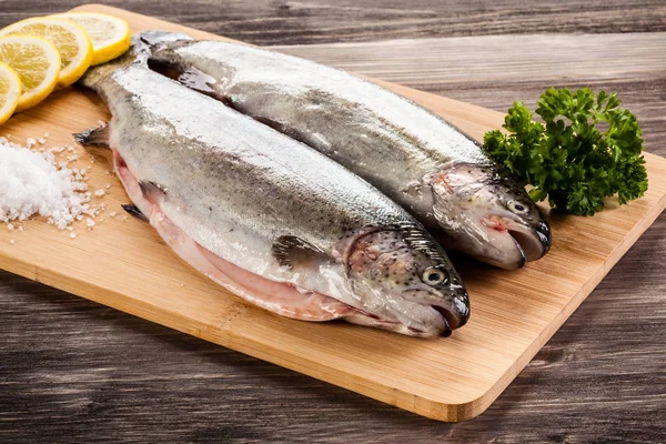 Fresh raw trouts on cutting board — Stock Image Fresh Raw Trouts Cutting Board Stock Photo