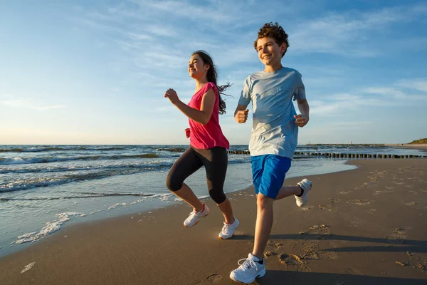 Ragazza Adolescente Ragazzo Esecuzione Saltando Sulla Spiaggia — Foto Stock