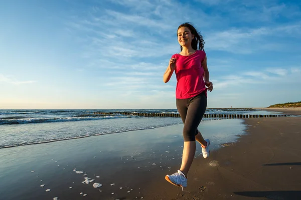 十几岁的女孩奔跑 跳跃在海滩上 — 图库照片