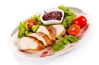 Roast chicken fillet and vegetables on white background clipart