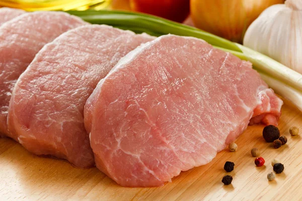 Rohe Schweinekoteletts Auf Schneidebrett Und Gemüse — Stockfoto