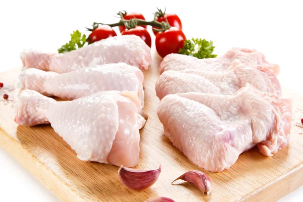 生鶏の羽と白い背景の上のまな板にばち状核突起 — ストック写真