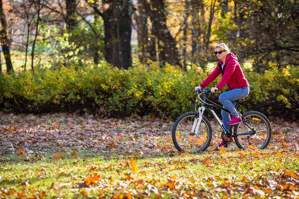 健康生活方式 妇女骑自行车在城市公园 — 图库照片