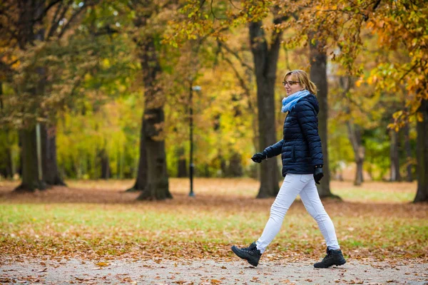 都市公園で歩いている中年女性 — ストック写真
