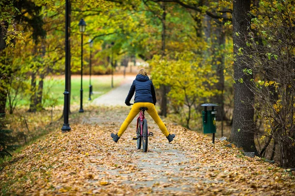 Urban biking - woman riding bike in city park