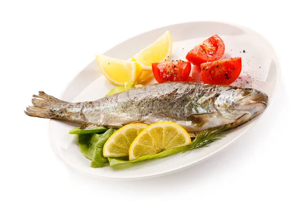 Fish dish - roast fish and vegetables on white background