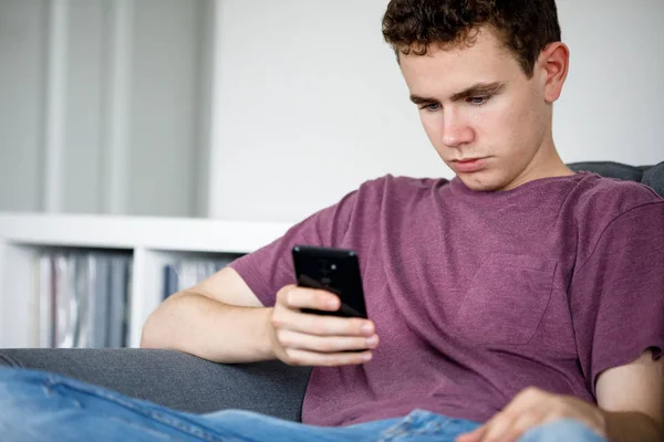 Hombre Joven Usando Teléfono Inteligente Sentado Sofá —  Fotos de Stock