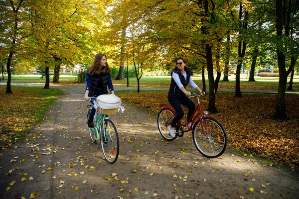 秋の公園で一緒に自転車に乗る母と娘 — ストック写真