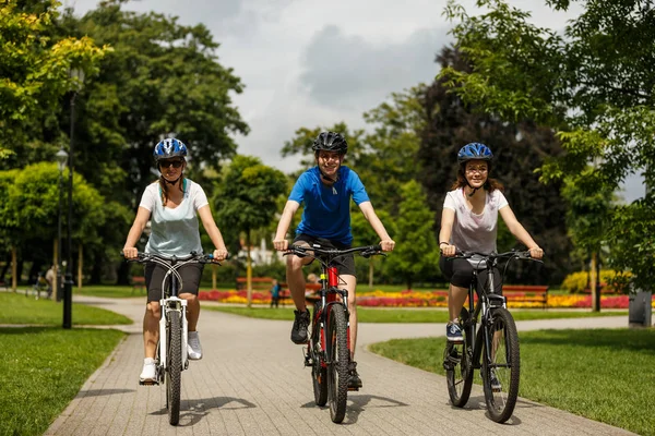 Biciclette Famiglie Nel Parco Estivo Con Fiori Colorati Sullo Sfondo — Foto Stock