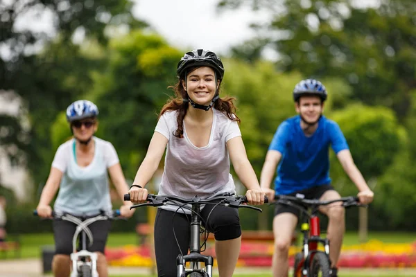 Family Riding Bikes Summer Park Colourful Flowers Background — Stockfoto