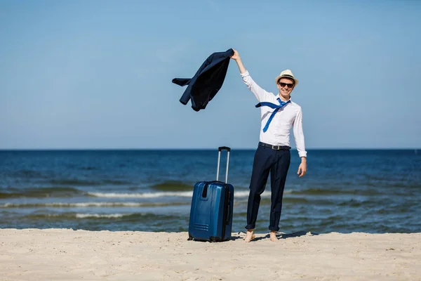 ビジネスマンスーツケースが海を背景にポーズ 夏休みのコンセプト — ストック写真