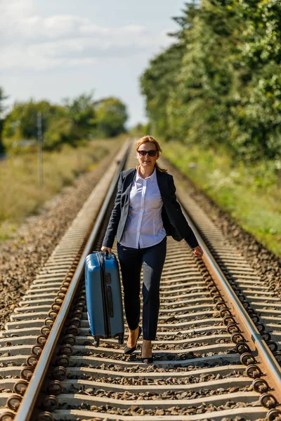 鉄道の道路に立ってスーツを着た女性 休暇と旅行のコンセプト — ストック写真
