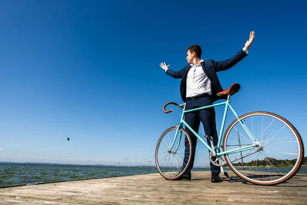 海辺の自転車で桟橋に立つスーツの男 — ストック写真