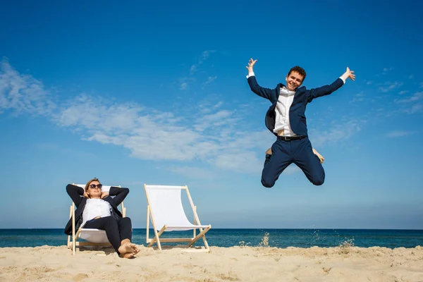Woman Man Suits Sandy Beach Man Having Fun Jumping Seaside — Stock Photo, Image